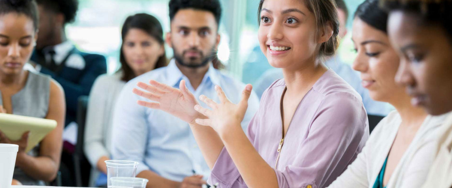 A young happy woman speaking to a group.