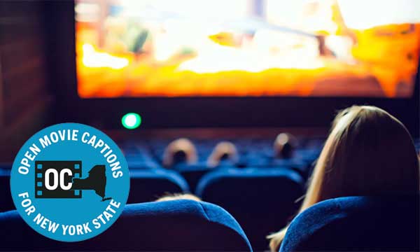 View from the back of the movie theater of a woman watching a movie