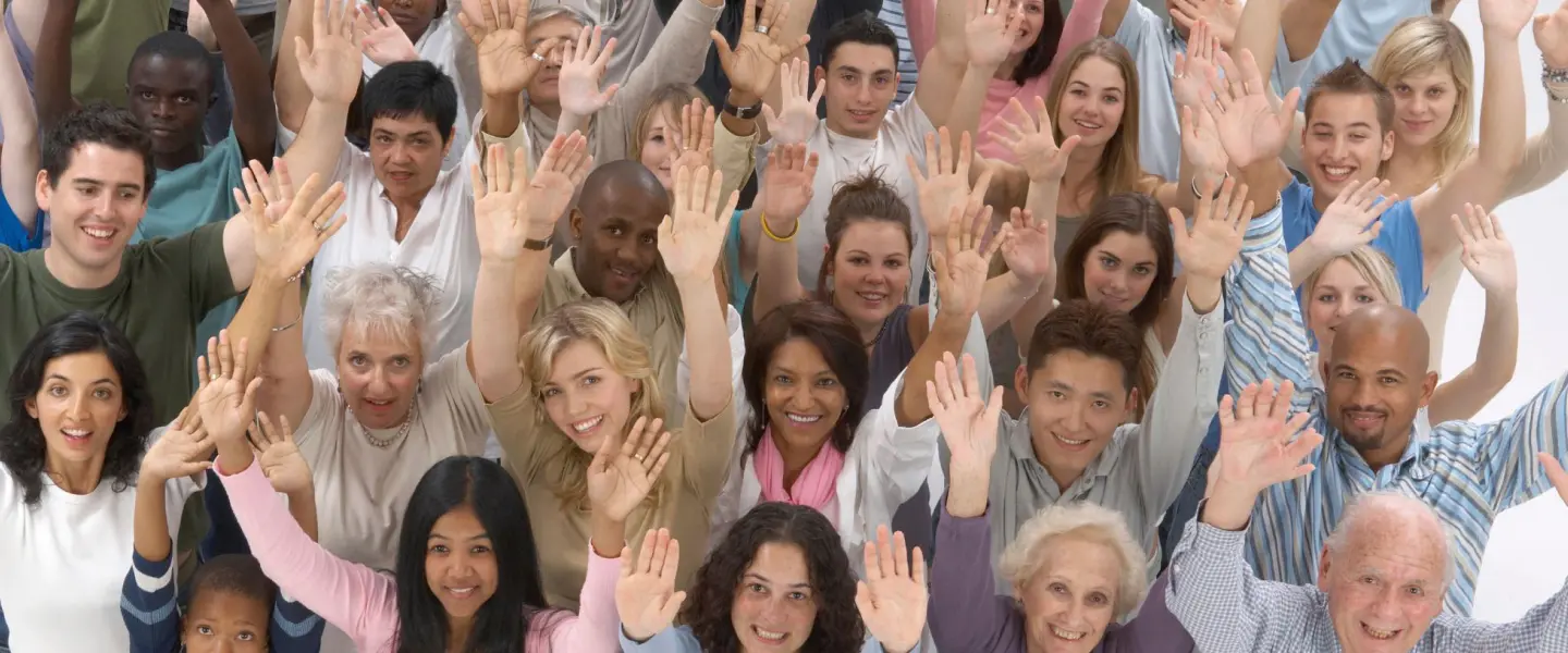 Downward view of a group of people celebrating with their hands in the air.