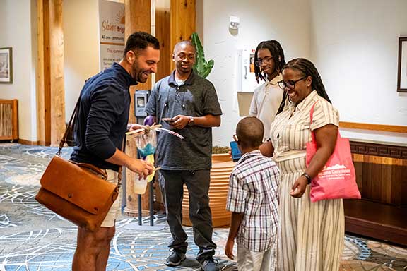 Group of people with a child enjoying each other at the HLAA 2024 Convention