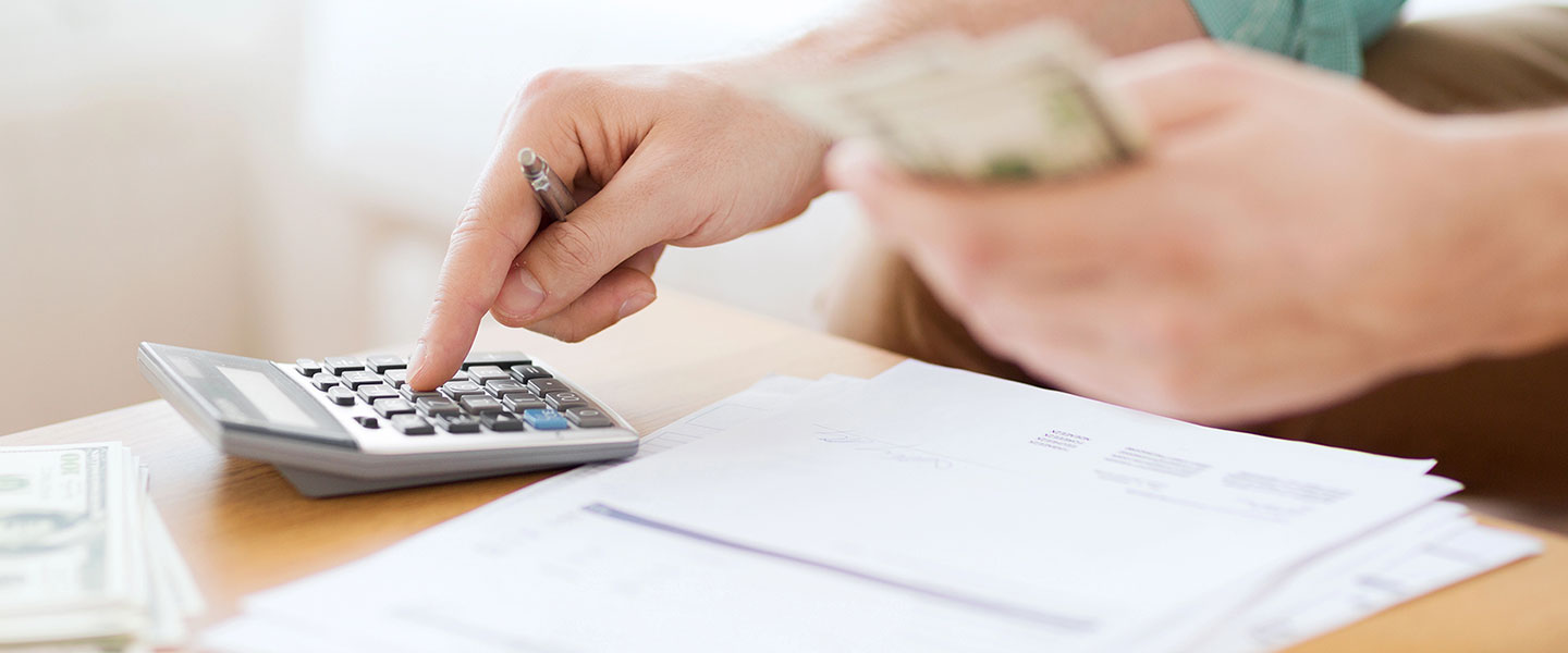 I hand tapping a calculator to figure out finances