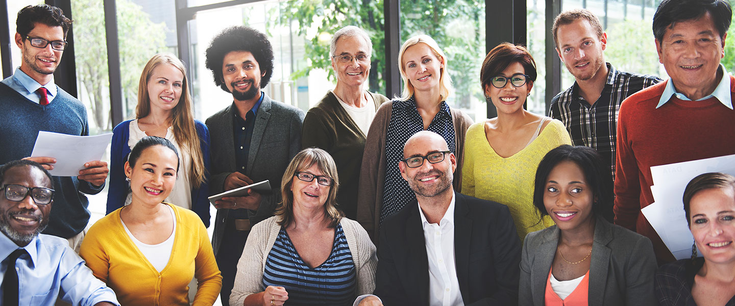 Large group of co-workers smiling in the office.