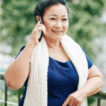 Elderly woman of Asian descent talking on mobile phone