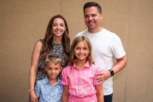 A family of four smiling inside