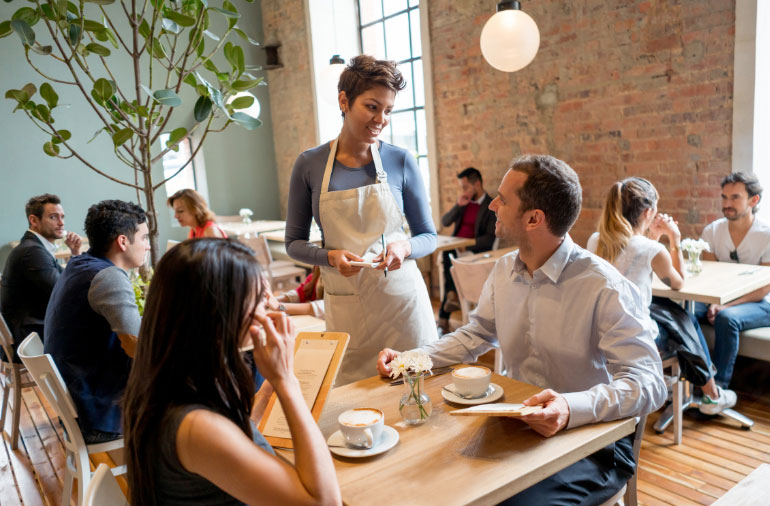 A scene at a busy restaurant of patrons eating and ordering food.