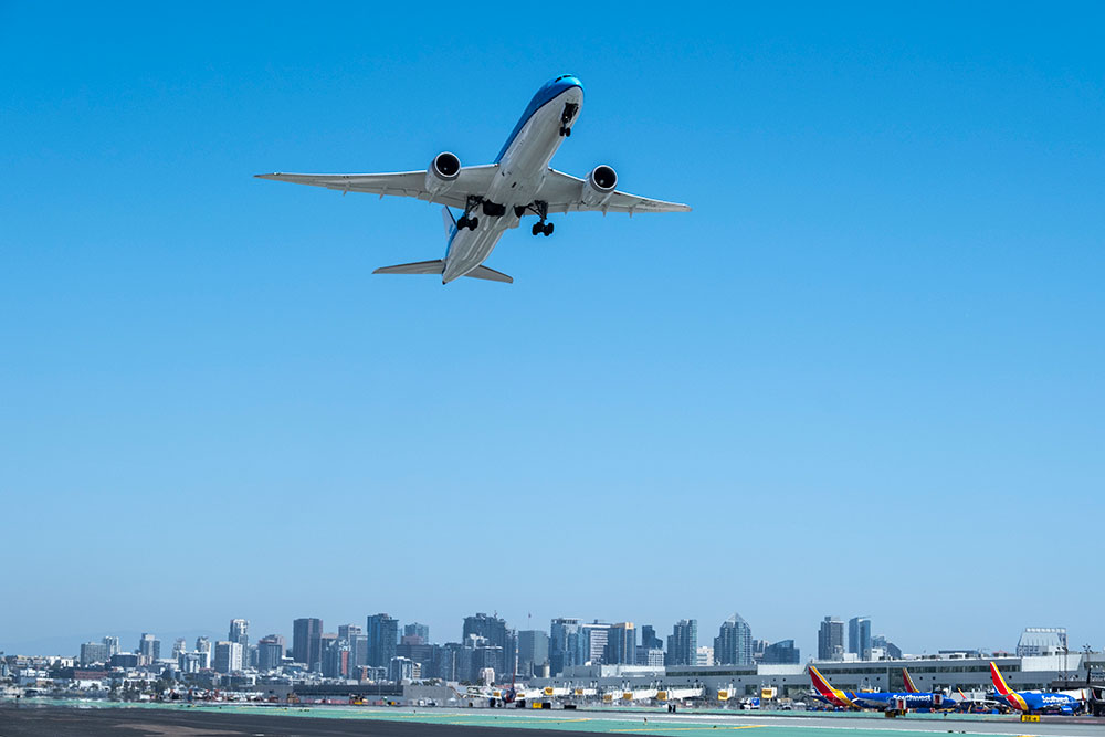 Plane ascending over an airport in clear blue skies