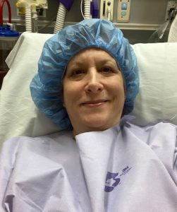 Terry wears a hospital gown and hat