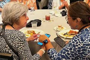 Two women talking with assistive listening devices and hearing aids.