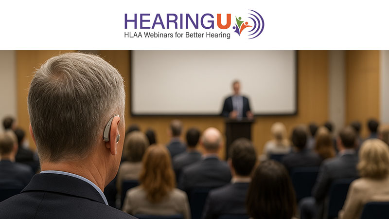 Man wearing hearing aids in the foreground with blurred background of crowd during a presentation